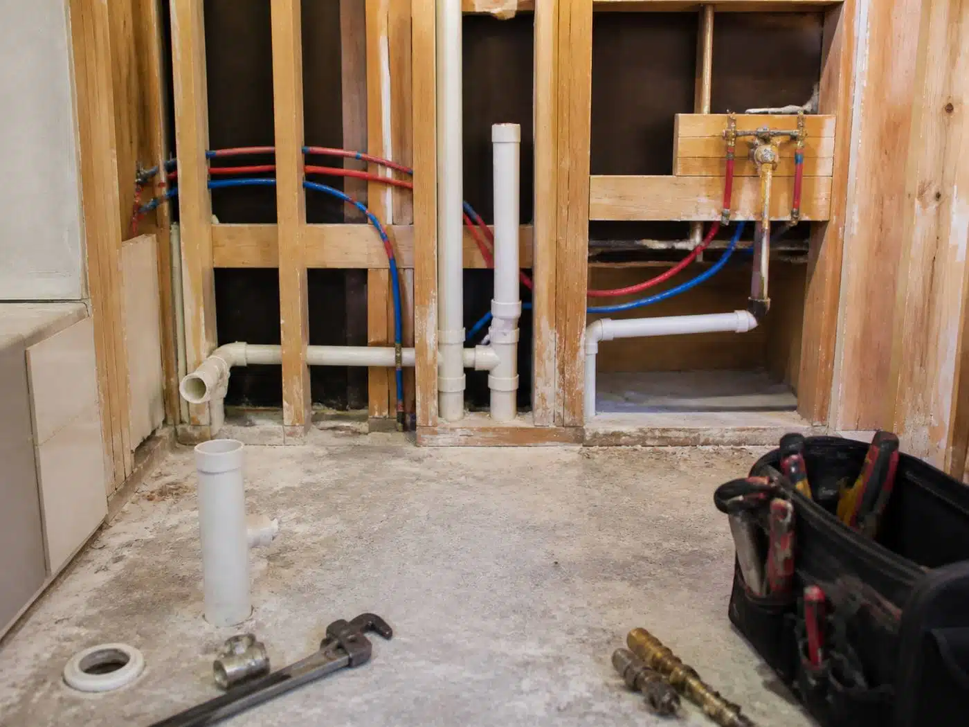 Wider view of the work area, bathroom remodel plumbing rough-in with PEX supply lines and PVC drain stubs in a Denver home