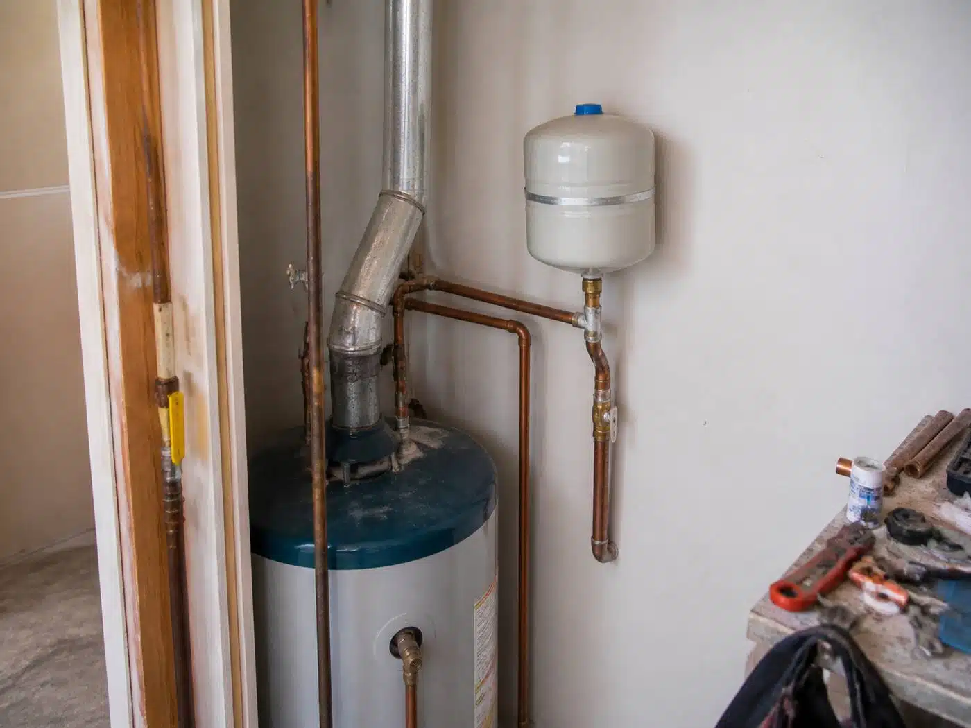 Wider view of the work area, thermal expansion tank mounted on the cold water line above a Denver water heater
