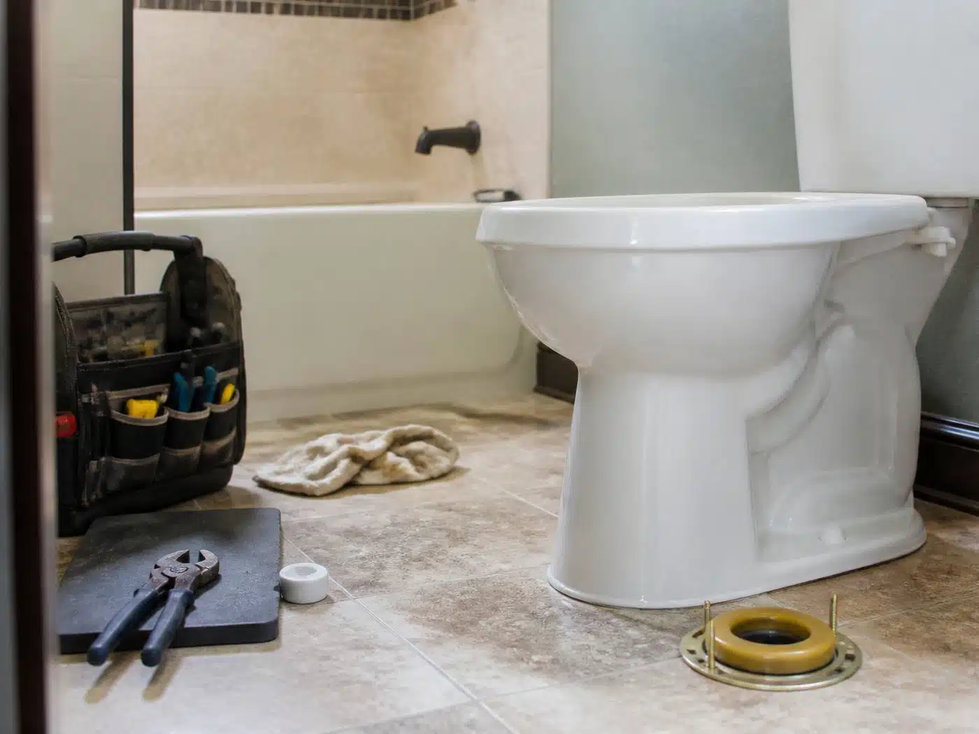 Wider view of the work area, toilet being set on a new wax ring and closet flange in a Denver bathroom