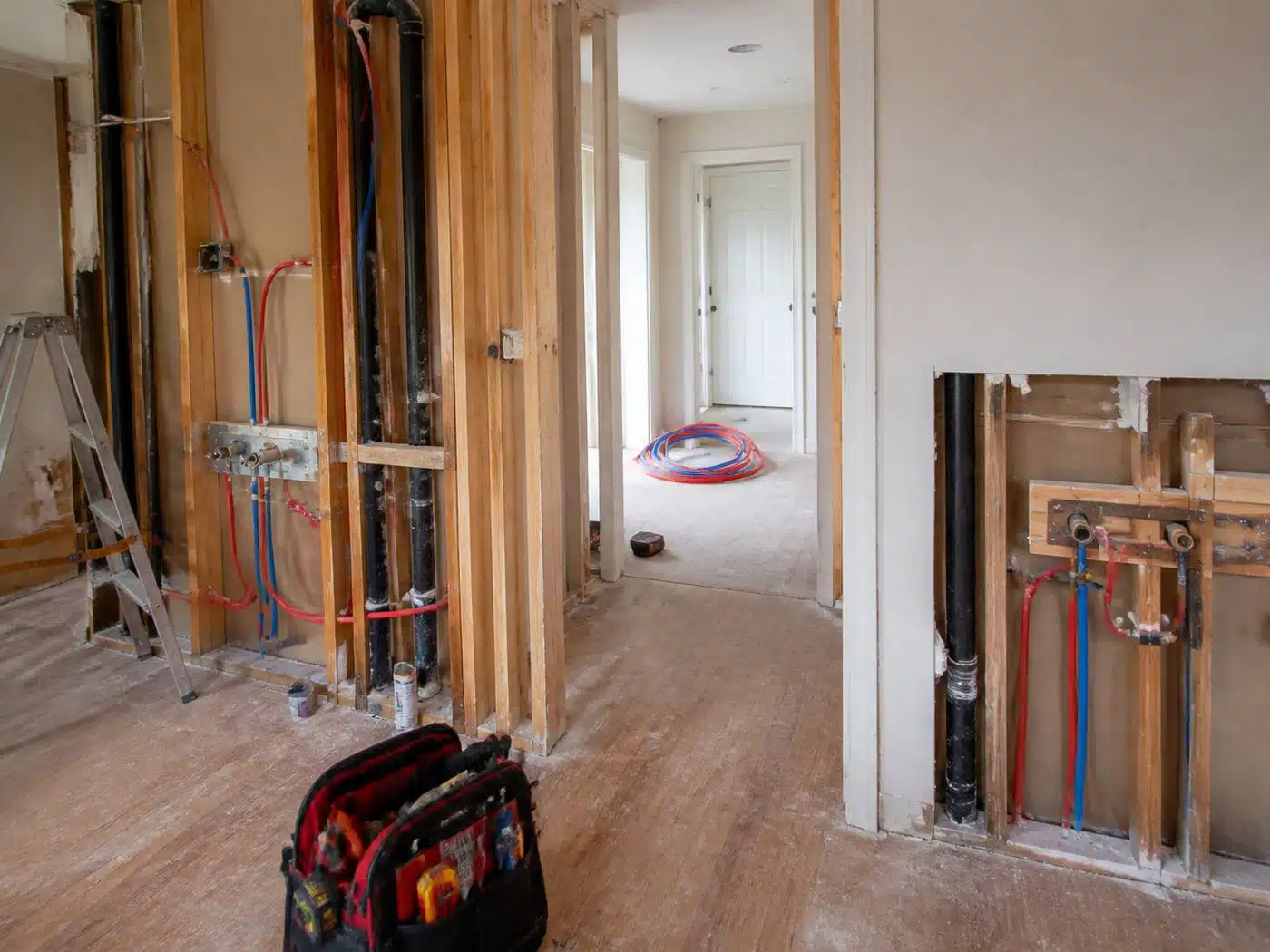 Wider view of the work area, whole house repipe in progress with open wall channels and new PEX lines in a Denver home